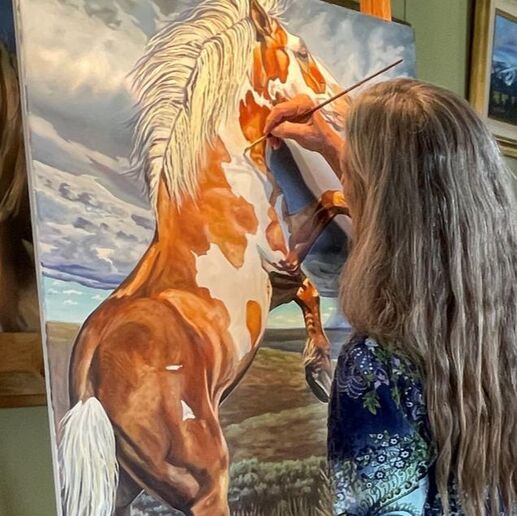 Melody at work in her studio on a mustang painting